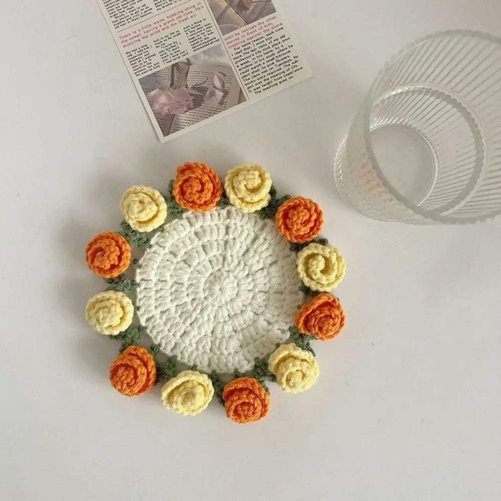 A bouquet of hand-crocheted roses in shades of orange and cream arranged on a white surface.