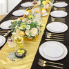 A display of gold rim plastic plates for weddings and parties set on a black tablecloth with floral arrangements.