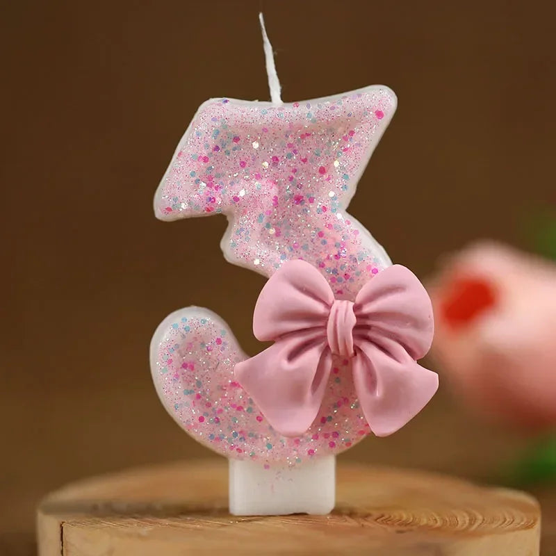 Taza de pastel con glitter rosa y vela con forma del número 3 y un lazo rosa