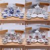 A collection of 15 miniature porcelain tea sets and cups in blue and white are displayed on a wooden table.