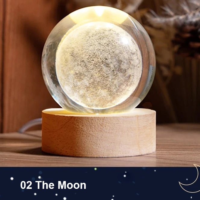 Galaxy crystal ball night light with a spherical glass orb resting on a wooden base