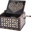 An antique engraved wooden music box with a lid showing text and a small metal key.