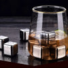 Reusable stainless steel ice cubes floating in a glass of amber liquid