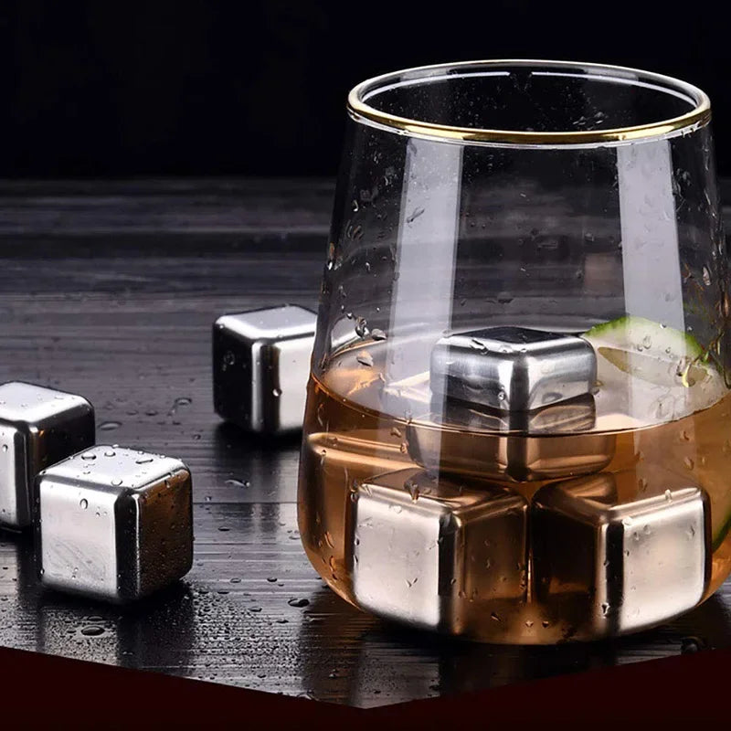 Reusable stainless steel ice cubes floating in a glass of amber liquid