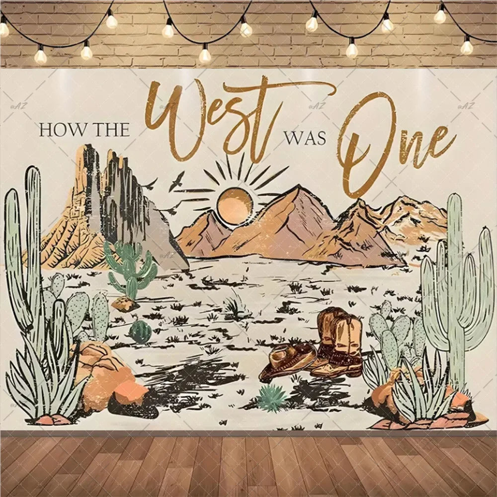 A rustic backdrop featuring a desert landscape with cacti and mountains for a Wild West cowboy birthday party.