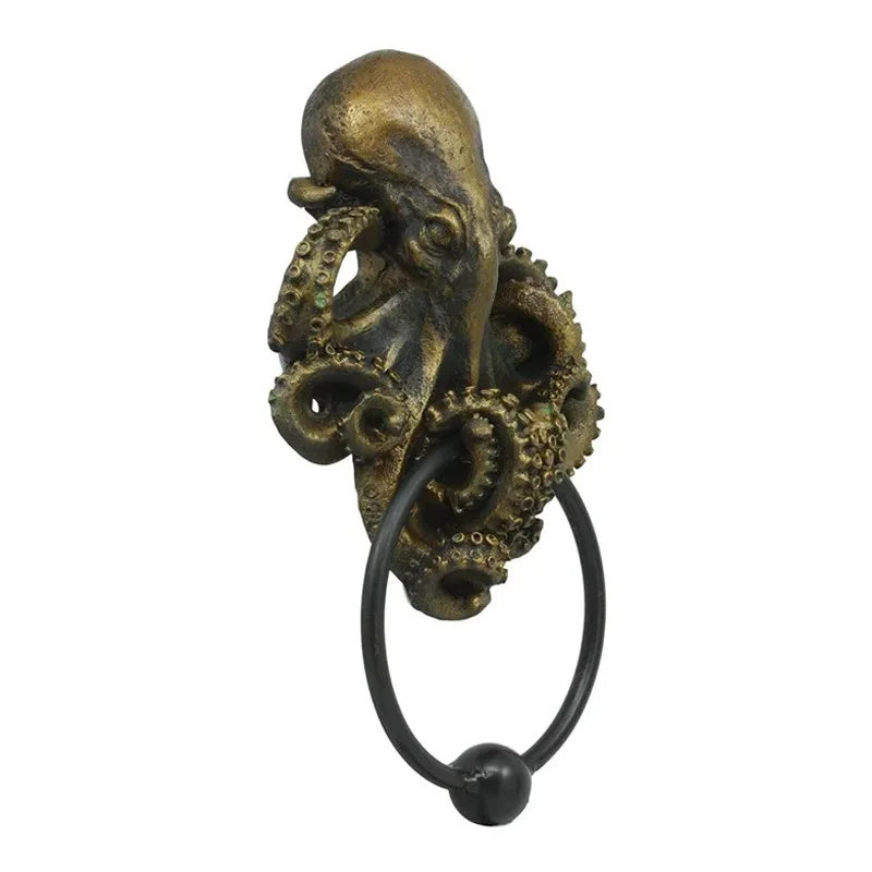 A bronze-colored octopus skull door knocker with a cast iron ring.