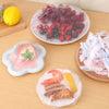 Reusable clear cling film used to wrap and store various foods like berries, meat, and fruit.