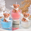 A set of three soy wax teddy bear candles in glass jars with ribbons, featuring pink, blue, and white colors.
