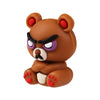 A small, brown silicone bear figurine with purple eyes and red accents.