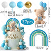 A cake decorated with blue and gold balloon toppers, including a bear figure and rainbow foam balls.