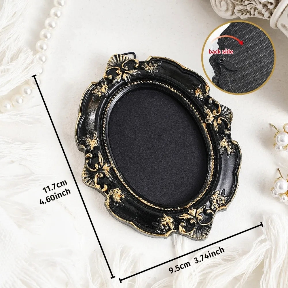 A black vintage baroque resin hanging photo frame with gold accents displayed on a white surface.