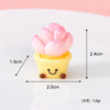 A small yellow pot holding pink resin rose charms for crafting and dollhouse decoration