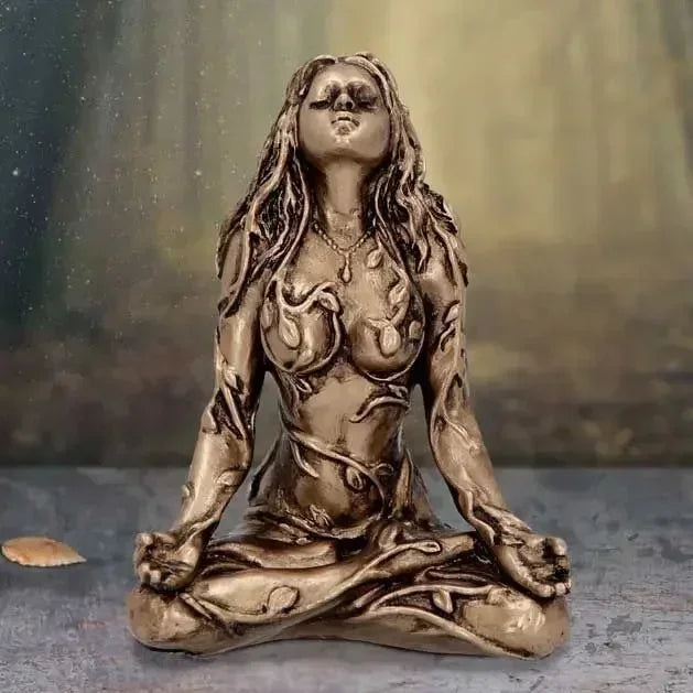 A bronze statue of a female figure with long flowing hair in a meditative pose, representing Mother Earth Gaia.