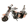 A vintage iron motorcycle figurine with a patina finish, displayed on a desk.