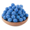A pile of bright blue textured resin beads for jewelry making in a wooden bowl.