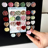 A collection of eight heart-shaped fridge magnets featuring various colors and checkered patterns.
