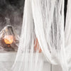 Black creepy gauze cloth draped over a window with orange light and smoke effect for Halloween decor