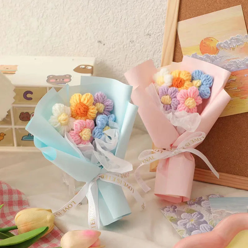A bouquet of handmade crochet flowers in pink and blue hues wrapped in sheer paper for a special occasion
