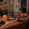 A table set with carved pumpkins, Halloween decorations, and candles for a spooky countdown box.