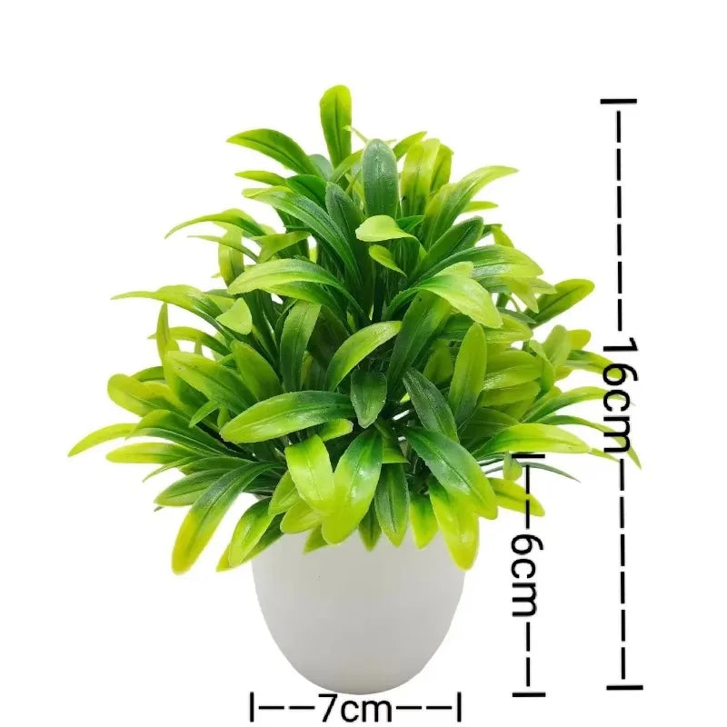 Künstliche Bonsai-Pflanze in weißem Topf mit grünen Blättern und Maßstab.
