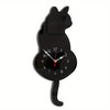 A black cat shaped pendulum wall clock with a moving tail.