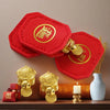 Red felt lucky turtle charms with gold accents displayed on a wooden surface.