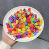A pile of colorful flower and star hair claw clips for kids in various bright colors