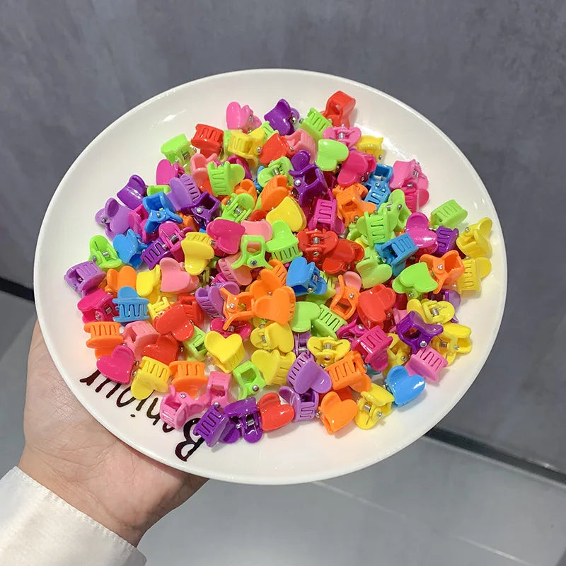 A pile of colorful flower and star hair claw clips for kids in various bright colors