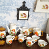 A collection of handcrafted miniature mushroom tableware including cups and saucers displayed on a wooden surface.