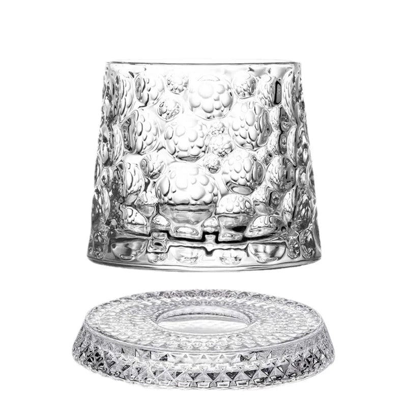 A clear crystal whiskey glass with a textured relief design and matching coaster.