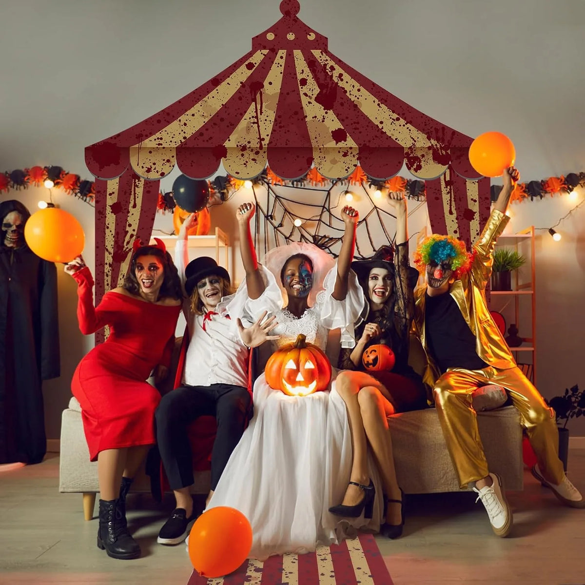 A group of people dressed in horror costumes posing under a large tent arch banner for Halloween