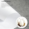 A close-up view of white cotton canvas material with a small piece of dark brown leather resting on it.