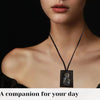 A close-up of a woman wearing a black multi-symbol Catholic pendant necklace on her neck.