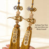A pair of brass gourd and five emperor coins hanging ornament made of gold-toned metal.