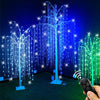 A weeping willow tree light display with blue and green LED lights illuminating a dark area.