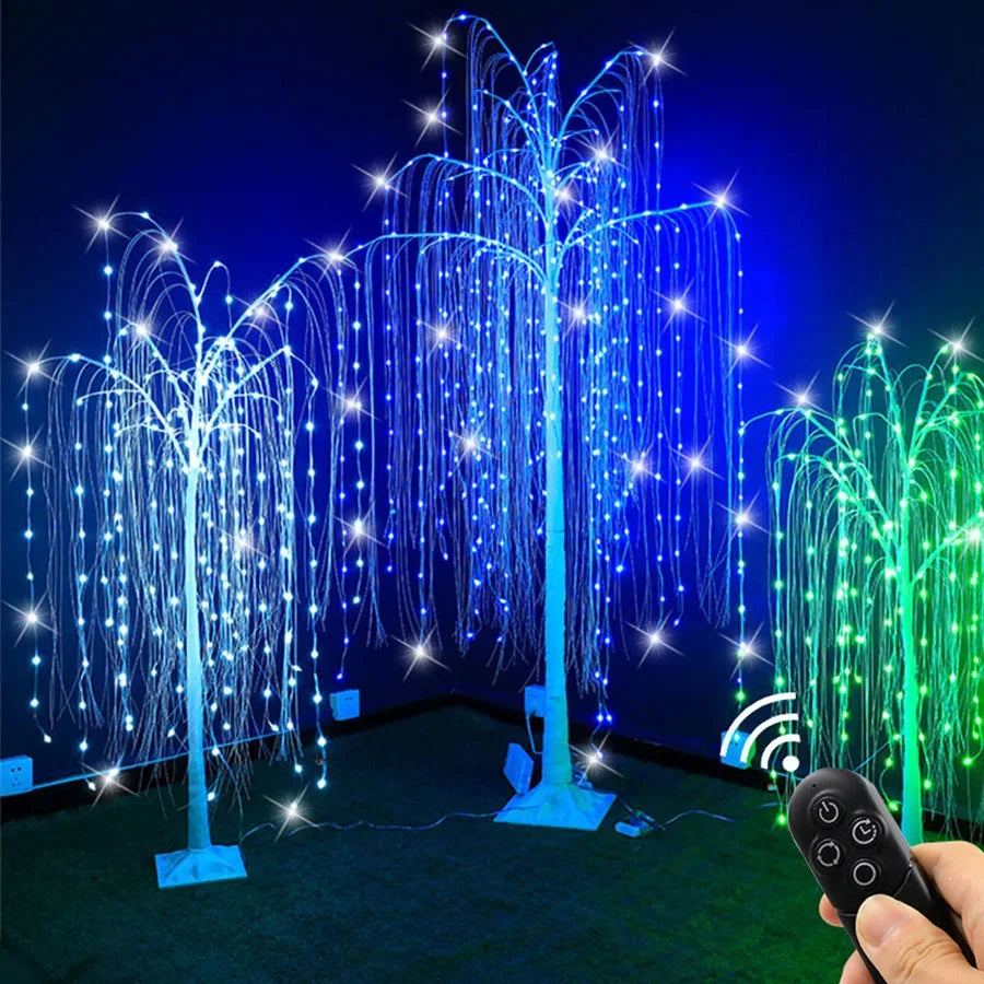 A weeping willow tree light display with blue and green LED lights illuminating a dark area.
