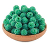 A pile of bright green textured resin beads for jewelry making in a wooden bowl.