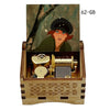 A wooden music box featuring a portrait of a woman in a dark hat and green coat, with brass and wooden components visible ins