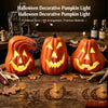 Three glowing orange carved pumpkins decorated for Halloween with jack-o'-lantern faces on a wooden surface.