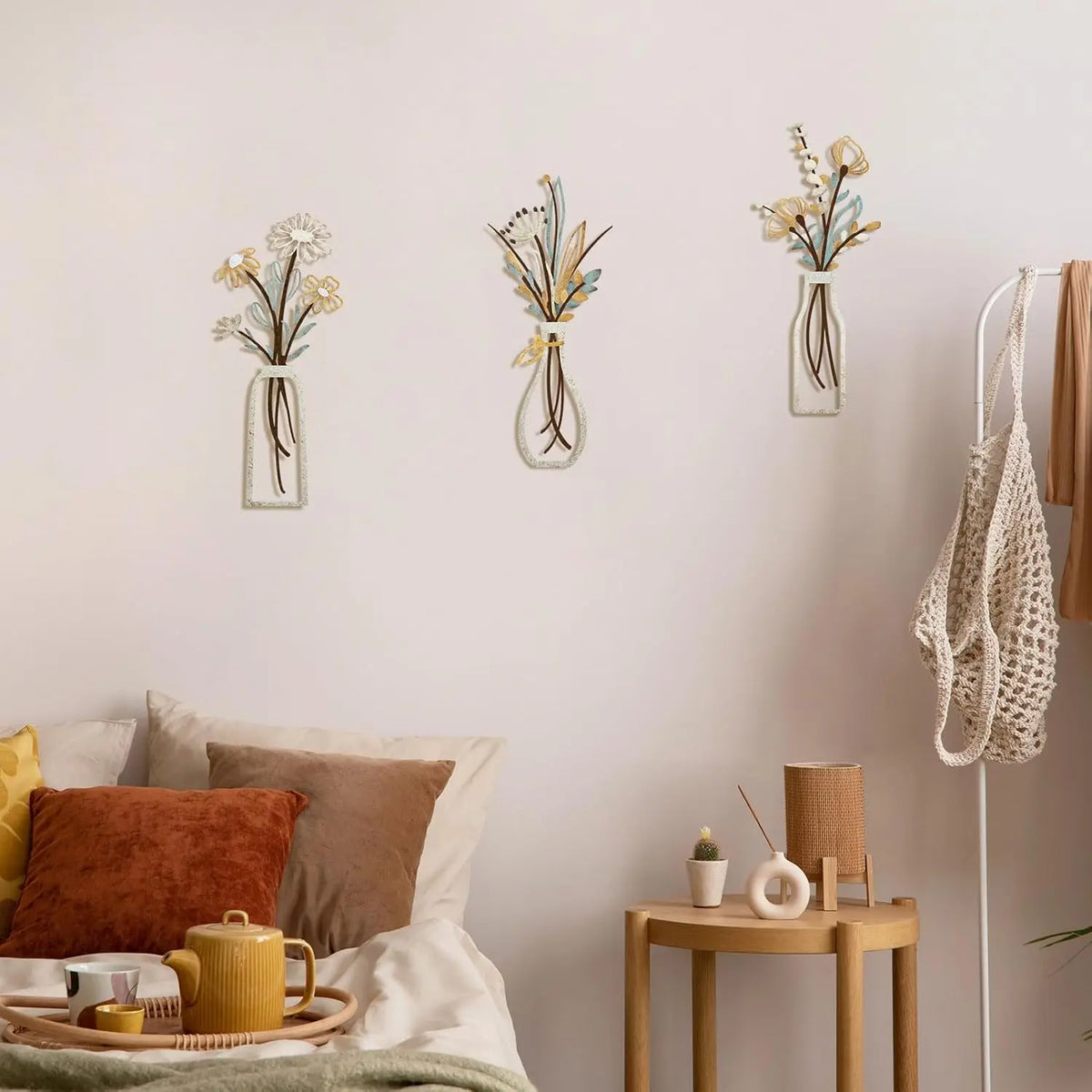 A set of three rustic metal flower wall art pieces displayed on a white wall.