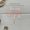A rose gold acrylic birthday cake topper with the words Happy Birthday on a stick.