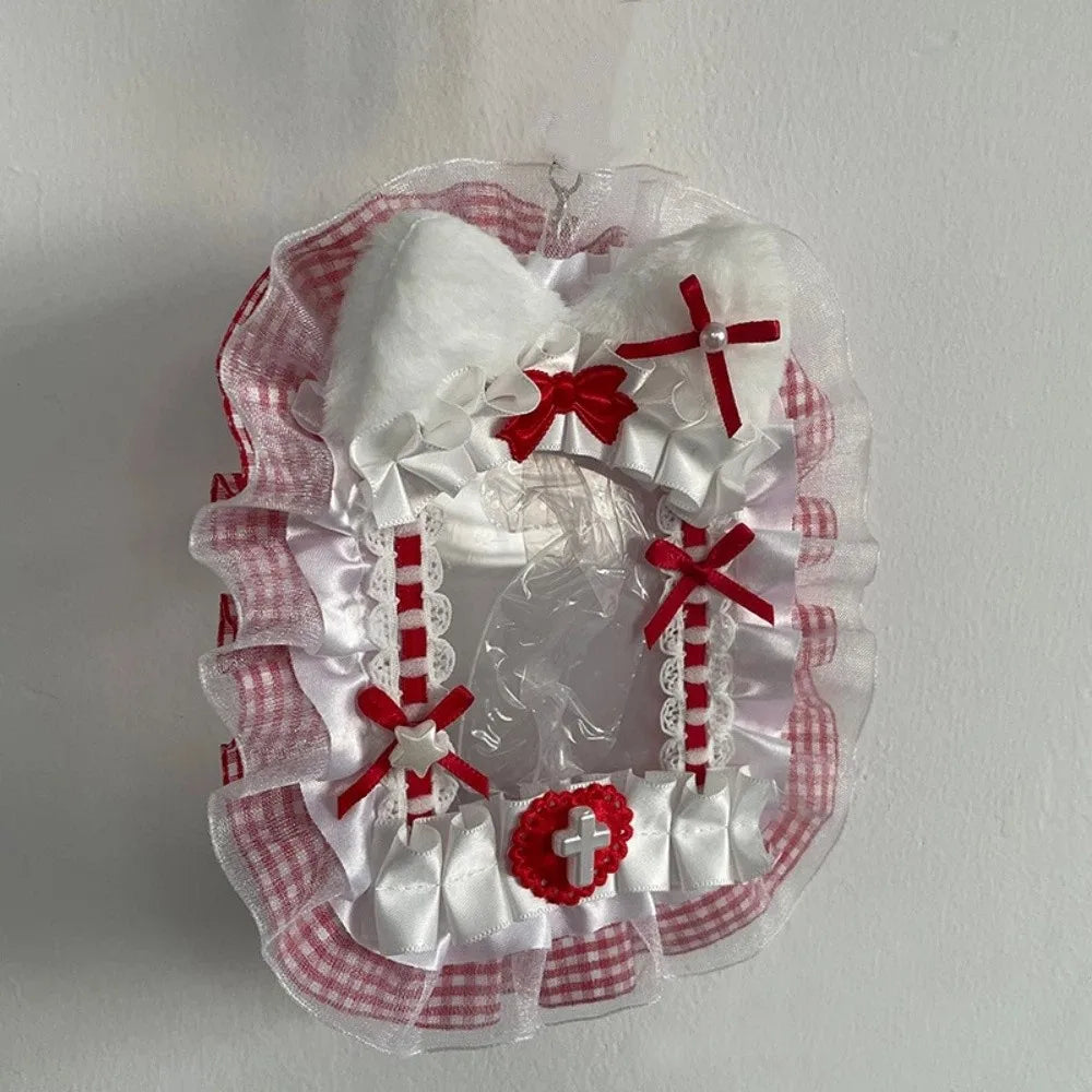 Porte-cartes en plastique clair décorée d'un ruban vichy blanc et rouge et d'un charm de croix rouge.