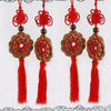 Three red tassel wall decorations featuring intricate knot designs and gold accents.