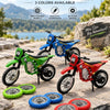 A collection of three 1:12 dirt bike models in green, blue, and red with spare wheels displayed on a stone surface.