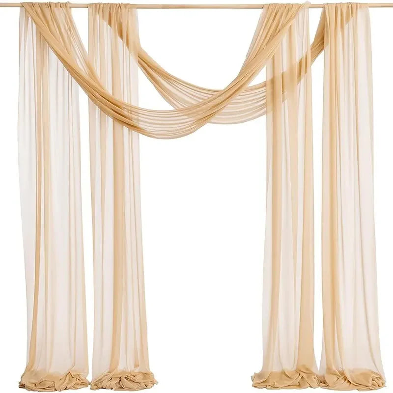 A set of two sheer beige chiffon fabric panels draped as a wedding arch backdrop.