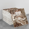 A stack of faux marble 3D self-adhesive wall tiles showing swirling brown and white patterns.