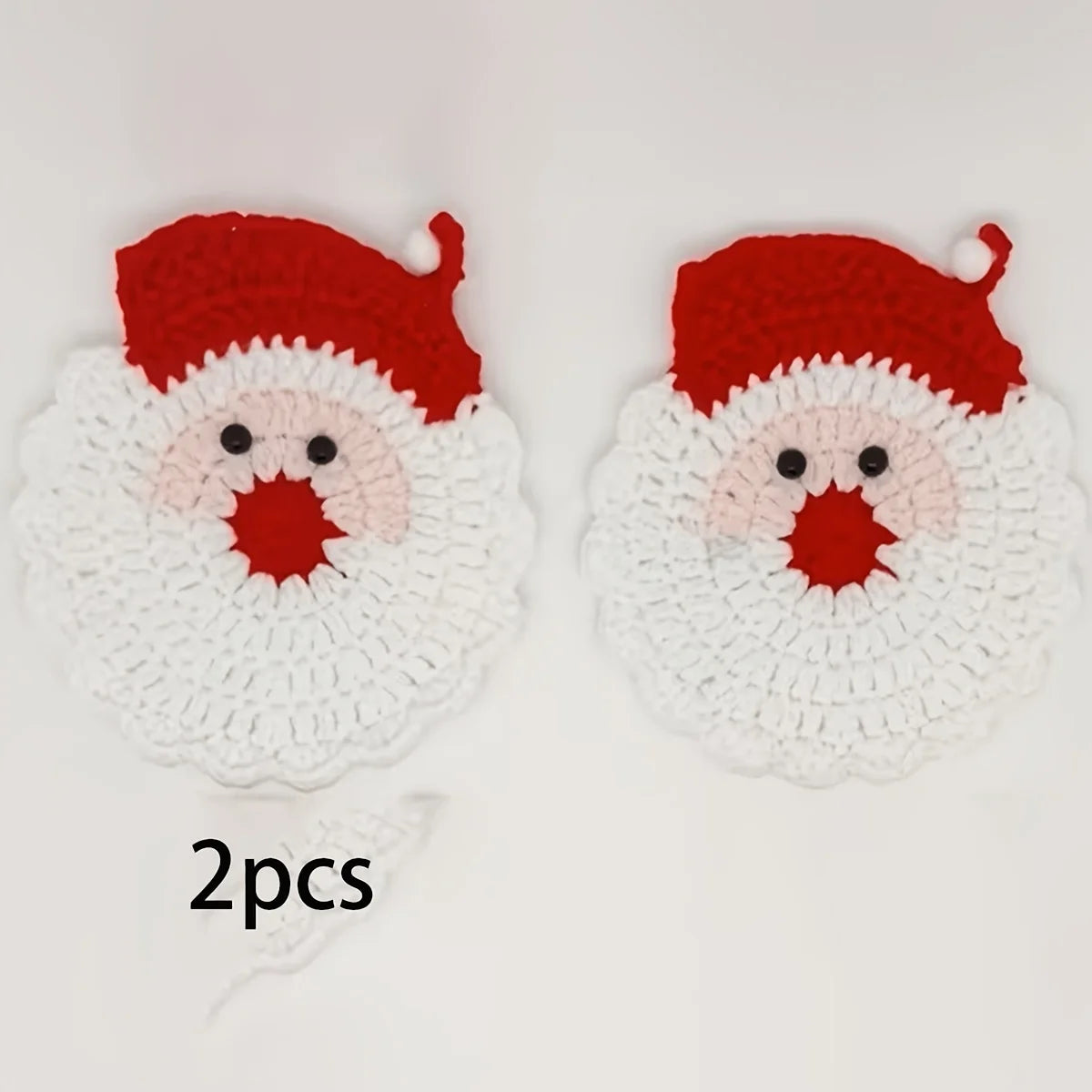 A pair of handmade crochet Santa Claus coasters featuring red and white yarn details.