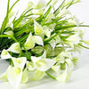 A bouquet of artificial white calla lilies with green stems for home and event decoration.