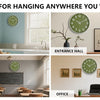 A collection of images showing a minimalist green wall clock hanging in various indoor settings like a kitchen, entrance hall