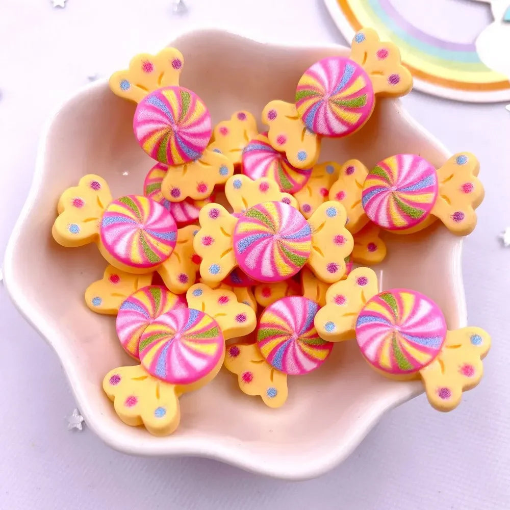 A pile of colorful, swirling candy resin cabochons in pink, yellow, and green hues on a white dish.